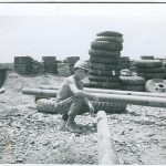SSG Schwarz near motor pool with shot-up pipe sections used for bunker construction.